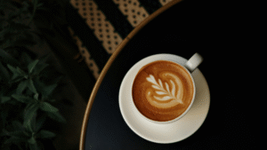 Tasse Cappuccino mit Latte Art von oben auf dunklem Tisch