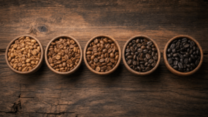 Verschiedene Kaffeebohnen Röstungen von hell bis dunkel auf Holzuntergrund